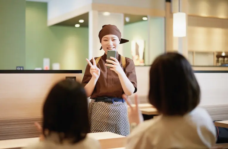 ゆず庵スタッフがお客様をゆず庵オリジナルフレームで記念撮影している様子